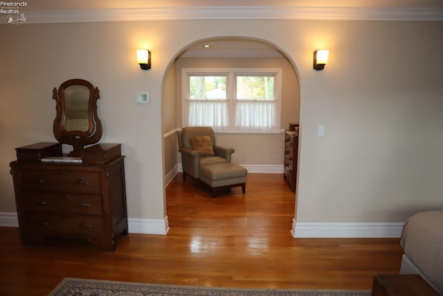 sitting room with wood-type flooring and crown molding