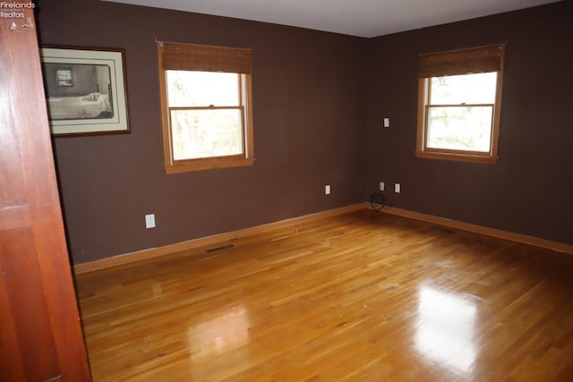 unfurnished room with a wealth of natural light and light hardwood / wood-style floors