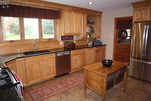 kitchen featuring dark stone counters, sink, and appliances with stainless steel finishes