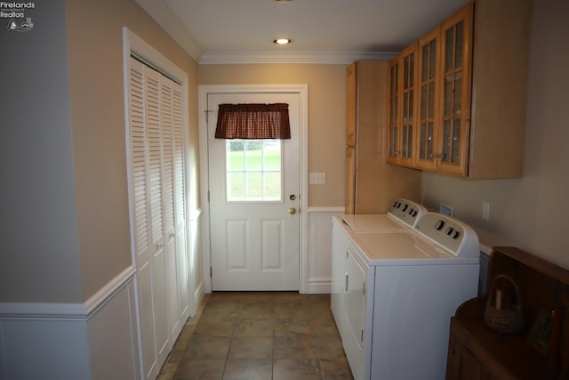 clothes washing area featuring cabinets, washing machine and dryer, and crown molding