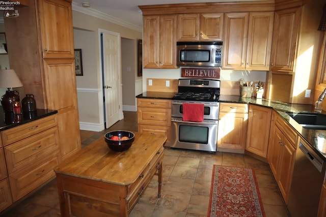 kitchen featuring dark stone countertops, crown molding, sink, and appliances with stainless steel finishes