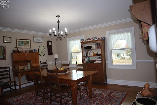 dining room featuring dark hardwood / wood-style floors, a chandelier, and ornamental molding