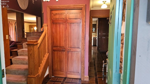 interior space with dark tile patterned flooring and crown molding