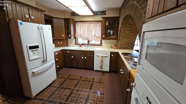 kitchen featuring white appliances, sink, and washer / dryer