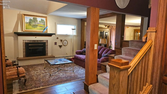 living room with hardwood / wood-style floors, a fireplace, a baseboard radiator, and ornamental molding