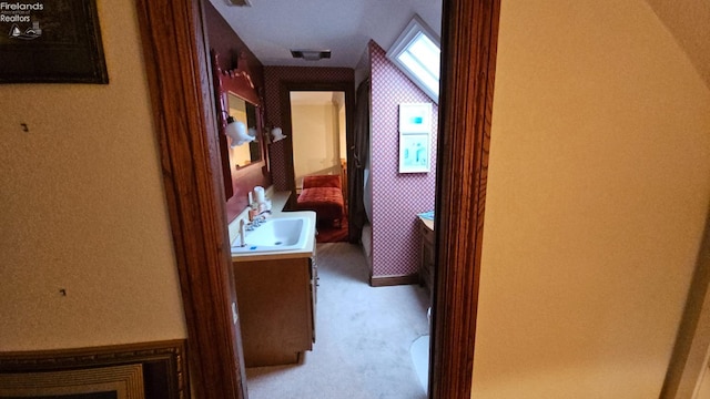 hall featuring light colored carpet and sink