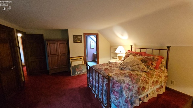 bedroom featuring dark colored carpet, lofted ceiling, and a textured ceiling