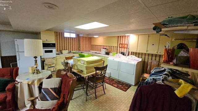 interior space with a paneled ceiling and washer and clothes dryer