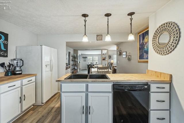 kitchen with dishwasher, butcher block counters, dark hardwood / wood-style floors, and decorative light fixtures