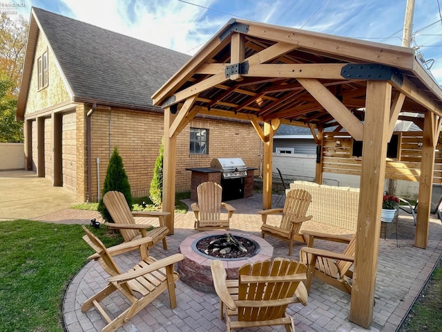 view of patio with a gazebo, grilling area, a fire pit, and a garage