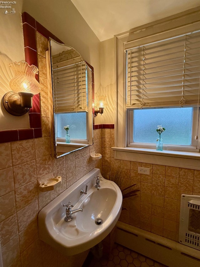 bathroom featuring tile patterned flooring, sink, baseboard heating, and tile walls