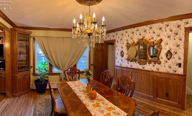 dining space with wood-type flooring, a textured ceiling, an inviting chandelier, and crown molding