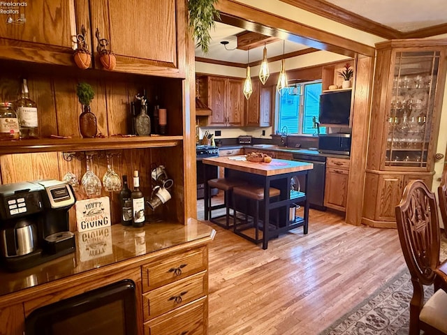 kitchen with black range with gas stovetop, crown molding, decorative light fixtures, light hardwood / wood-style flooring, and dishwasher