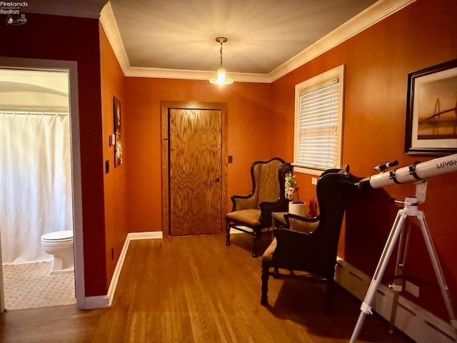 living area with hardwood / wood-style flooring and crown molding