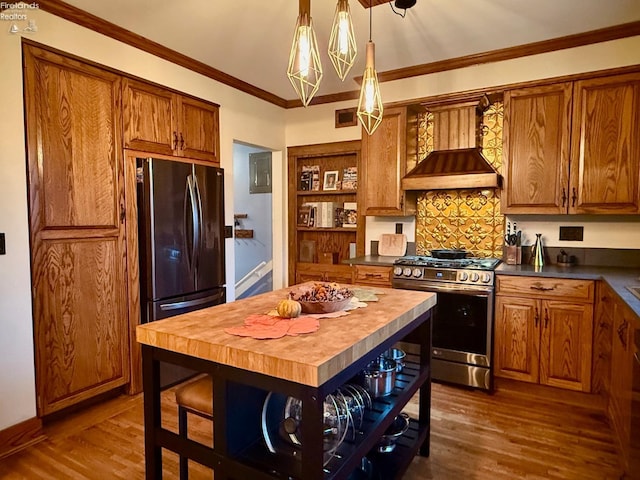 kitchen with dark hardwood / wood-style flooring, custom range hood, crown molding, stainless steel gas stove, and butcher block countertops