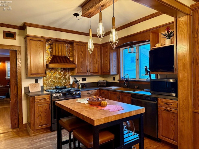 kitchen featuring appliances with stainless steel finishes, ornamental molding, custom range hood, decorative light fixtures, and hardwood / wood-style floors