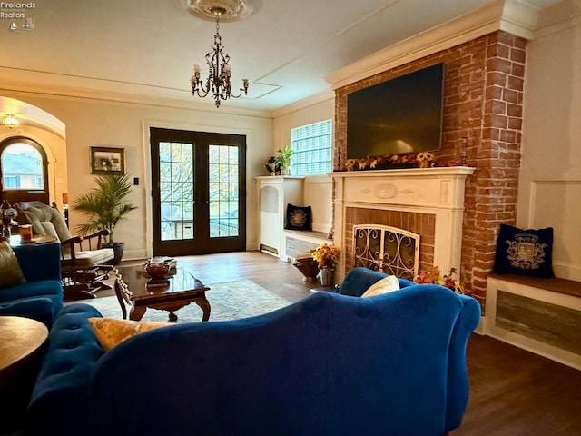 living room featuring a wealth of natural light, hardwood / wood-style floors, crown molding, and french doors