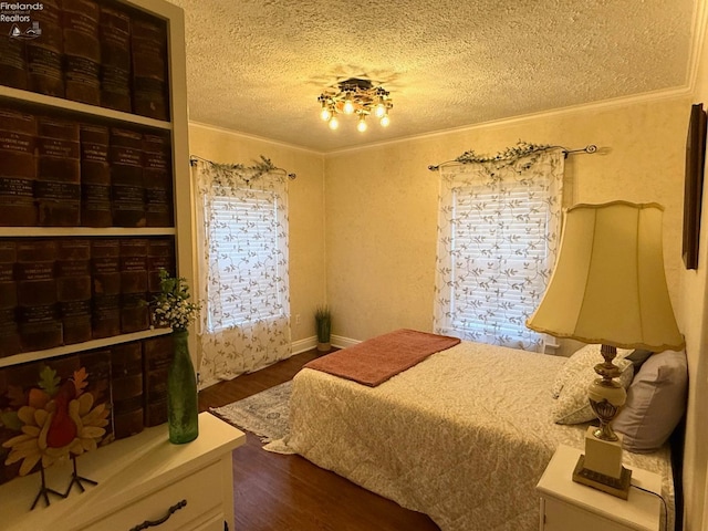 bedroom featuring dark hardwood / wood-style floors, crown molding, and a textured ceiling