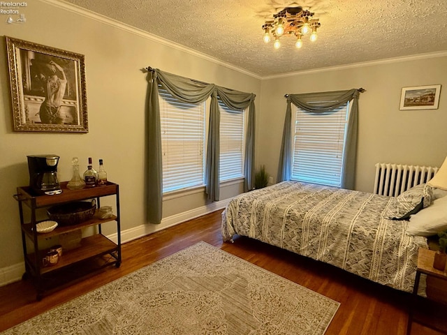 bedroom featuring radiator heating unit, a textured ceiling, dark hardwood / wood-style floors, and multiple windows