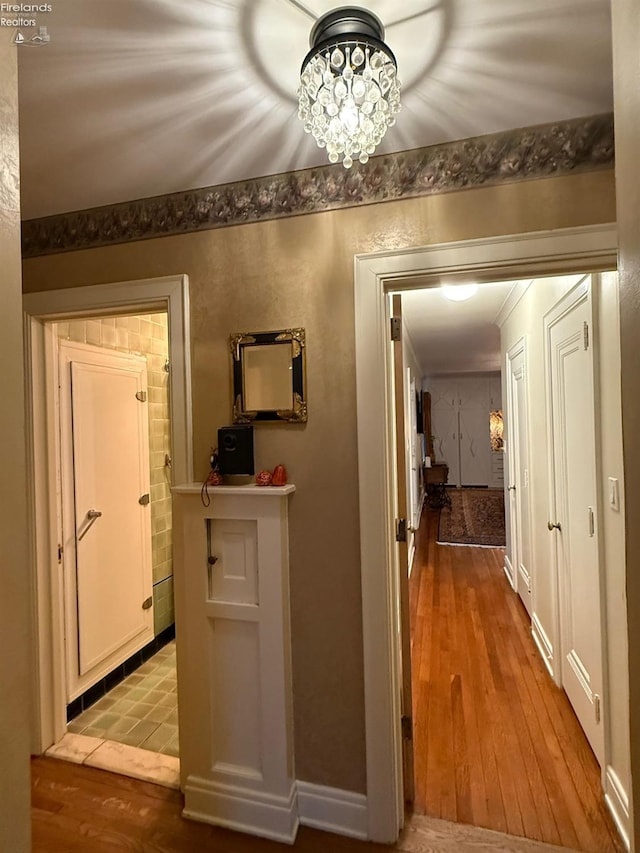 corridor featuring hardwood / wood-style floors and a chandelier