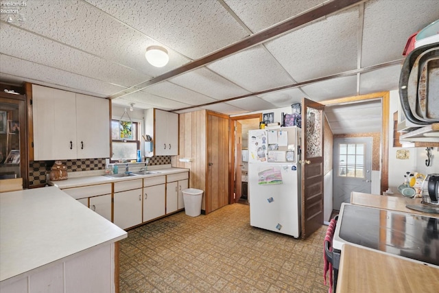 kitchen with white cabinetry, sink, stove, white refrigerator, and decorative backsplash