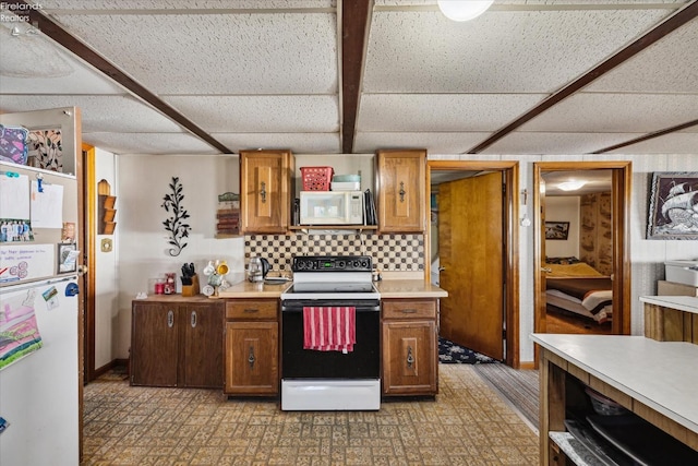 kitchen with white appliances, a paneled ceiling, and decorative backsplash