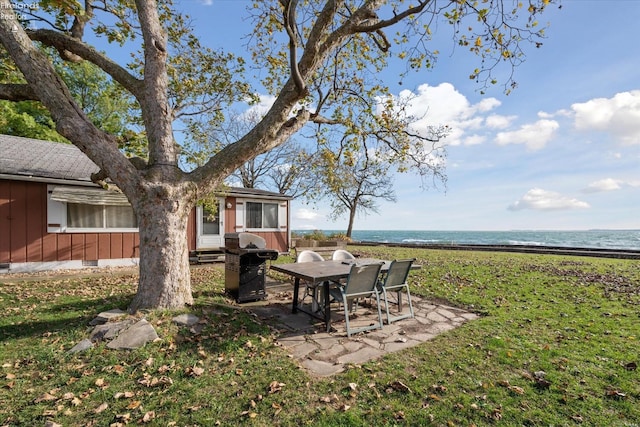 view of yard featuring a view of the beach, a water view, and a patio area