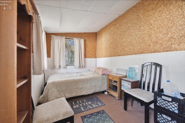 carpeted bedroom with wood walls and vaulted ceiling