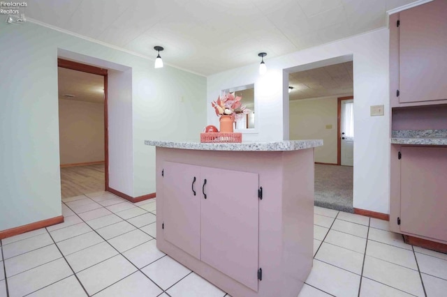 kitchen with light tile patterned floors, a kitchen island, and crown molding