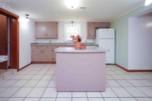 kitchen featuring pendant lighting, white refrigerator, light tile patterned flooring, and crown molding