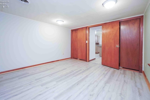 unfurnished bedroom with light hardwood / wood-style flooring, a closet, and crown molding