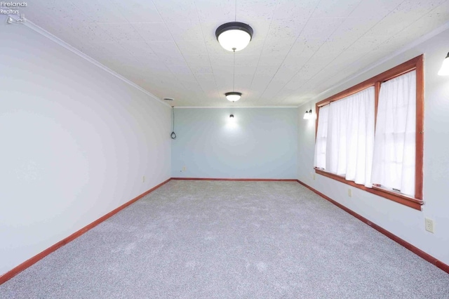 carpeted empty room featuring crown molding