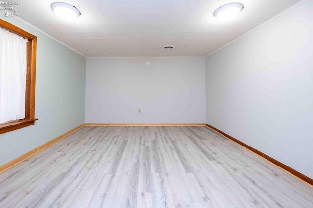 spare room featuring light wood-type flooring and ornamental molding