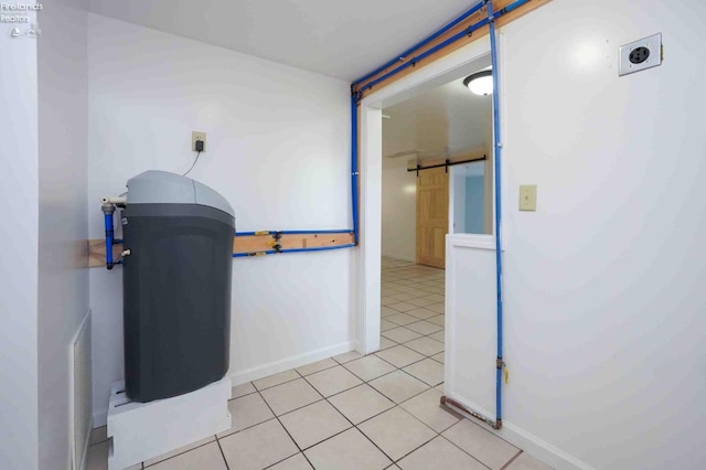 hall with light tile patterned floors and a barn door