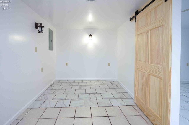 tiled spare room with a barn door and electric panel