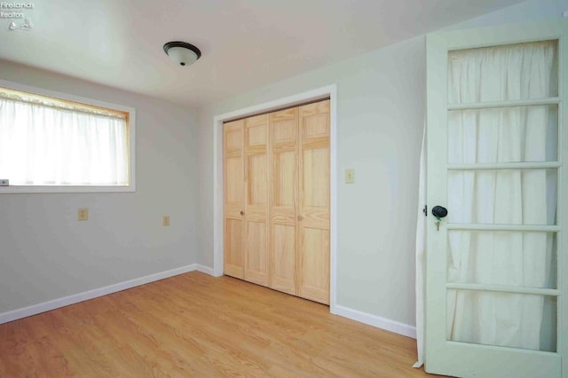 unfurnished bedroom with a closet and light hardwood / wood-style flooring