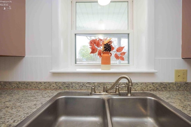 interior details featuring light stone counters and sink