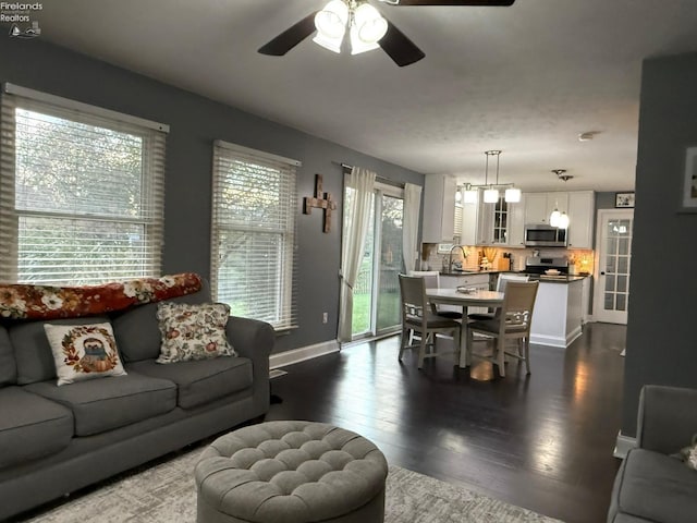 living room featuring ceiling fan, dark hardwood / wood-style floors, and sink