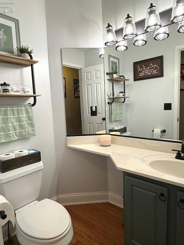 bathroom with toilet, vanity, and hardwood / wood-style floors