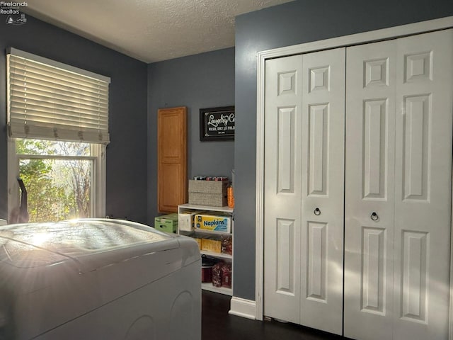 washroom with cabinets, a textured ceiling, and washer / clothes dryer