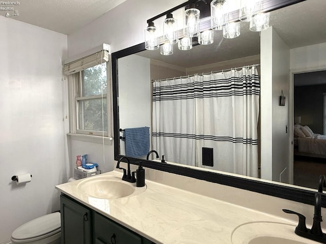 bathroom featuring vanity, toilet, and a textured ceiling