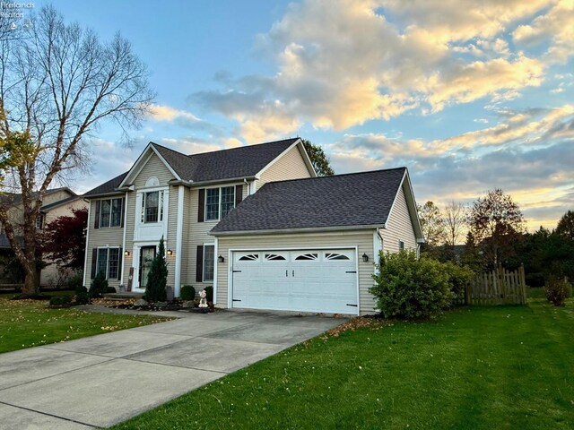 view of front of home featuring a lawn and a garage