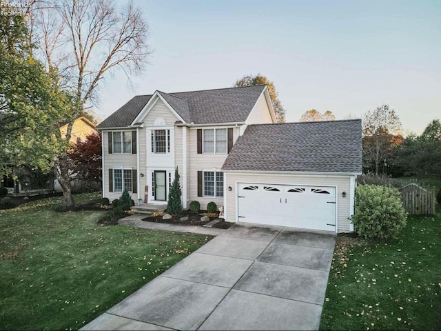 colonial-style house featuring a garage and a front yard