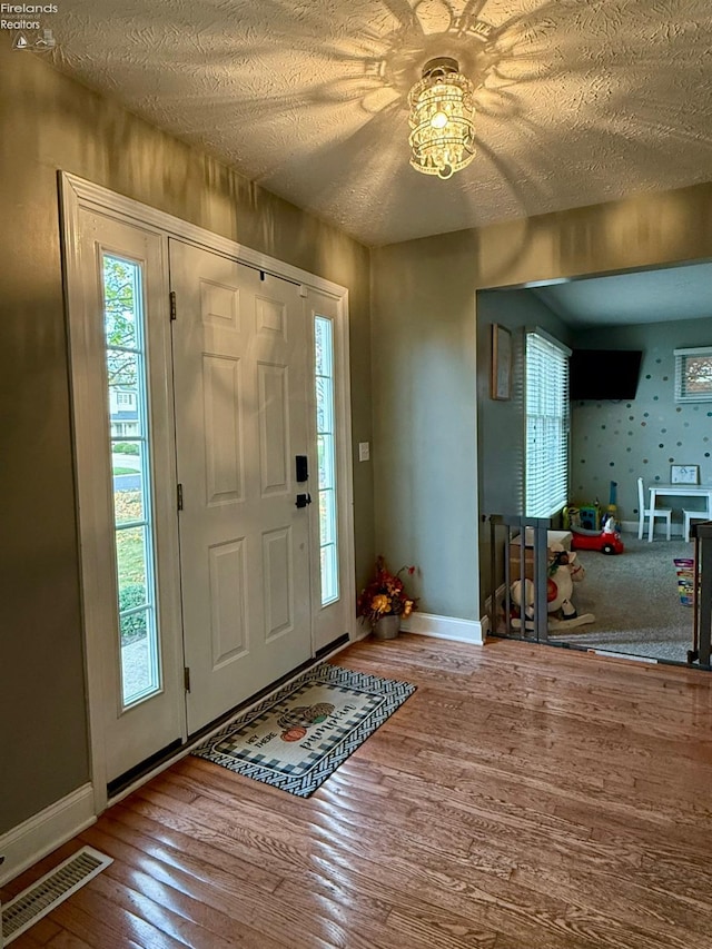 entryway with hardwood / wood-style flooring and a textured ceiling