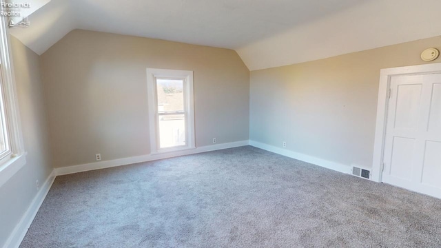 additional living space with lofted ceiling and carpet flooring