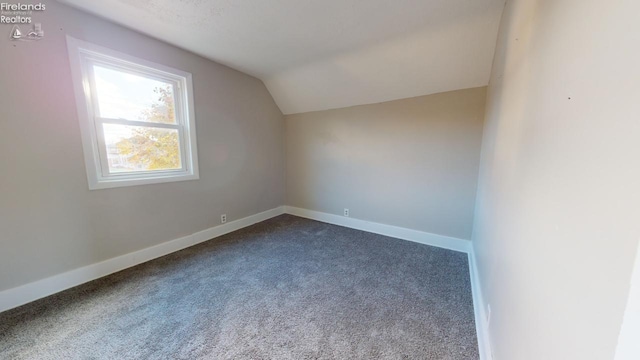 bonus room featuring dark carpet and vaulted ceiling