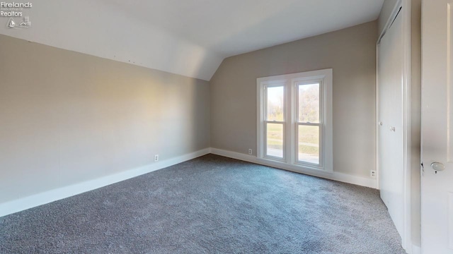 unfurnished room with carpet and lofted ceiling