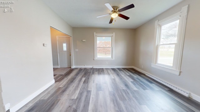 interior space with baseboard heating, ceiling fan, and hardwood / wood-style flooring