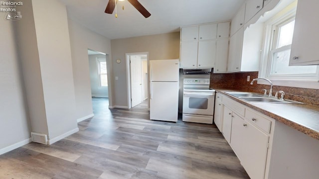 kitchen featuring plenty of natural light, white cabinetry, sink, and white appliances