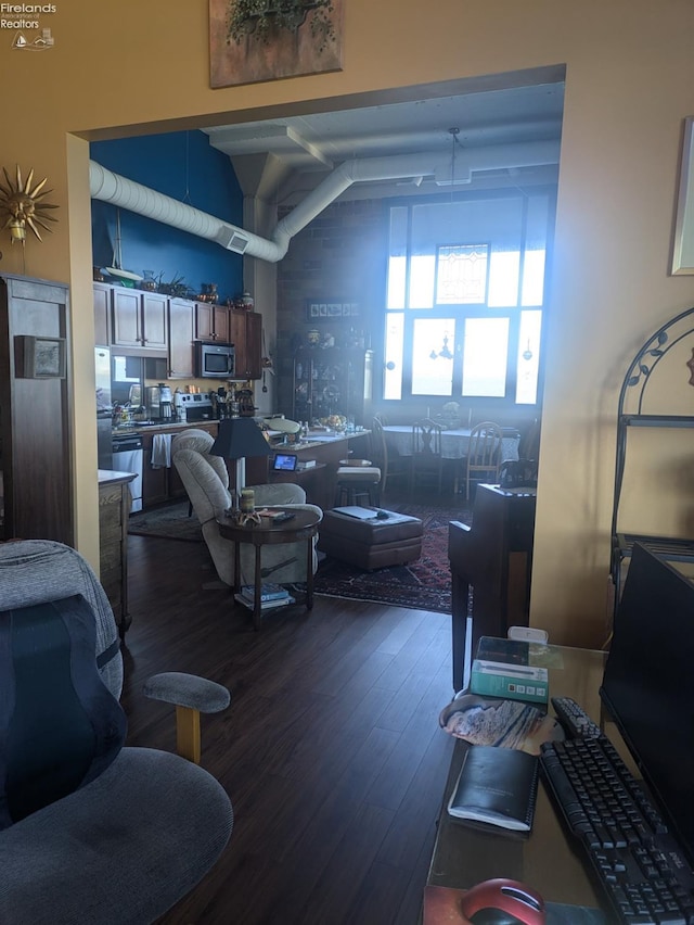 living room featuring dark wood-type flooring and vaulted ceiling